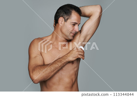 Skincare, man and deodorant for hygiene in studio, cosmetics and body in gray background. Male person, daily routine and clean armpit for odor or fresh, confident or pride and smile in mockup space 113344844
