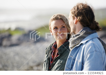 Happy, love and couple by ocean in winter for bonding, loving relationship and relax outdoors. Nature, travel and man and woman by seaside for holiday, vacation and weekend together for romance 113344921