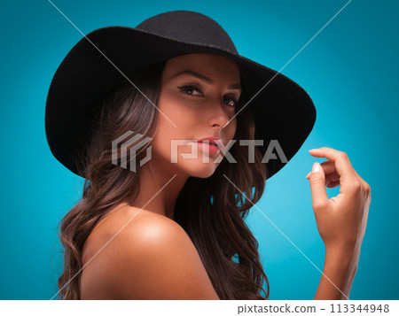 Woman, portrait and beauty in studio, cosmetics and bare shoulders on blue background. Female person, hat and face for dermatology on mockup space, accessories and isolated on backdrop for aesthetic Woman, portrait and beauty in studio, cosmetics and bare shoulders on blue background. Female person, hat and face for dermatology on mockup space, accessories and isolated on backdrop for aesthetic 113344948