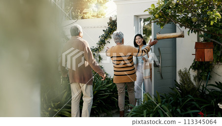 Happy family, open door and hug with flowers outdoor of home in backyard with daughter and parents with love. Reunion, welcome and woman with mom and dad, travel and surprise for holiday with embrace 113345064