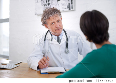 Medical, consultation and mature doctor with a checklist for healthcare, insurance or results of test. Clinic, patient and man in discussion of surgery or exam and professional paperwork for hospital 113345392