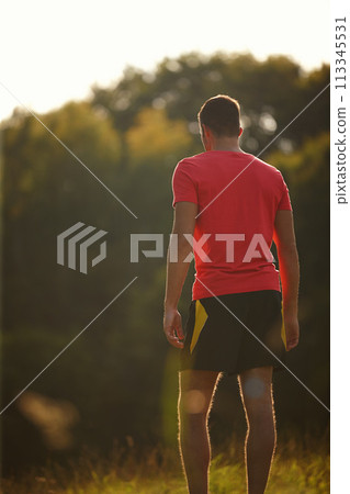 Rear view, man and break for running, fitness goals and workout for body health and physical training outdoor. Male runner or athlete and jog for cardio, strength or recreation on trail outside 113345531