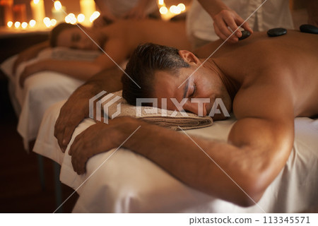 Couple, hot stone massage and treatment spa with masseuse, wellness and zen for body care at luxury resort. Physical therapy, detox and warm rocks for holistic healing with people for stress relief Couple, hot stone massage and treatment spa with masseuse, wellness and zen for body care at luxury resort. Physical therapy, detox and warm rocks for holistic healing with people for stress relief 113345571