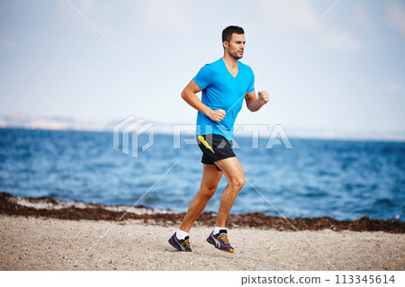 Running, athlete and man, beach and energy for practice in , exercise and health in nature. Workout, runner and training for marathon, forest and performance of speed of male person and outdoor 113345614