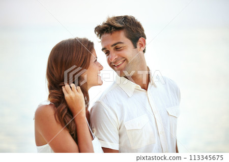 Happy couple, romantic and love by ocean on vacation and travel for honeymoon adventure in nature. Man, woman and smile face for bonding together with care, peace and trip for commitment in marriage 113345675