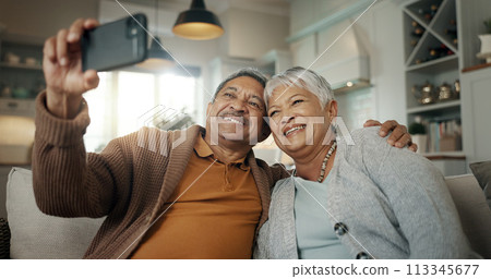 Senior couple, home and selfie while laughing on sofa and enjoying retirement together. Phone, smile and happy pensioners in family house, embracing each other and playful energy as elderly people 113345677