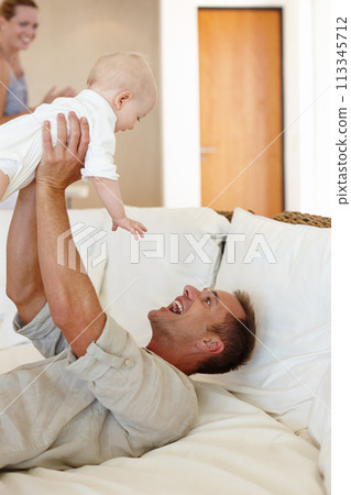 Funny, father and play with baby on sofa in home for love, care or family bonding together. Happy dad, kid and cute infant in living room for connection of mother, smile and parents laugh with child 113345712