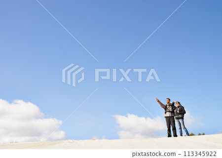 sand dunes, space and couple hiking for adventure, desert and travel on outdoor holiday for love or view. Sky mockup, explorers trip and nomad people pointing in Sahara terrain, nature or dry climate sand dunes, space and couple hiking for adventure, desert and travel on outdoor holiday for love or view. Sky mockup, explorers trip and nomad people pointing in Sahara terrain, nature or dry climate 113345922