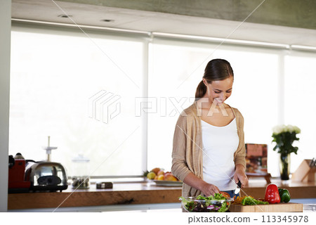 Woman, home and happy or preparing for salad with peppers, healthy or wellness or vegan. Female person, house or joyful with ingredients in kitchen for dinner, diet or vegetables or greens for recipe 113345978