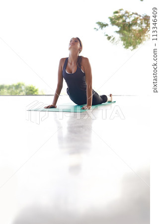Stretching, sunshine and woman with yoga and fitness with exercise and wellness. Person, yogi and girl meditate on the floor with training and workout with balance and zen with chakra and healthy 113346409