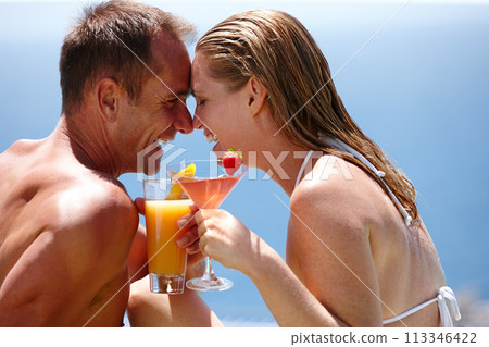 Couple, happy and toast with cocktail by swimming pool with care, vacation and love in summer. Man, woman and smile by ocean with drink, alcohol or outdoor in sunshine, water and holiday in Naples 113346422