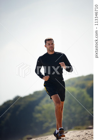 Running, athlete and man outdoor for sports with energy for practice, exercise and health in nature. Workout, runner and training for marathon, forest and performance of speed of male person Running, athlete and man outdoor for sports with energy for practice, exercise and health in nature. Workout, runner and training for marathon, forest and performance of speed of male person 113346710