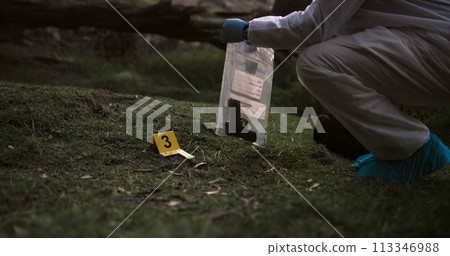 Crime scene, gun and investigator with evidence outdoor for forensics, analysis and investigation in forest or nature. Person hands with weapon, ppe and inspection or police search for clues in woods Crime scene, gun and investigator with evidence outdoor for forensics, analysis and investigation in forest or nature. Person hands with weapon, ppe and inspection or police search for clues in woods 113346988