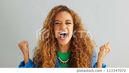 Excited woman, fist pump and celebration with deal, promotion or winning on a gray studio background. Portrait of happy female person or young winner with smile in surprise for bonus on mockup space 113347072
