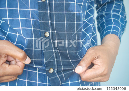 men hands with spilled water over his shirt 113348006