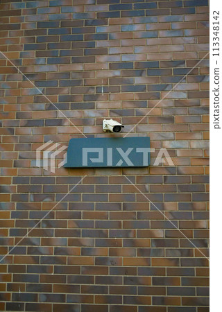 CCTV security camera operating on a wall  113348142