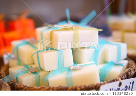 A stack of white soaps with blue ribbons in a basket 113348250