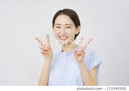 一個女人用雙手做和平標誌，白色背景 113348508