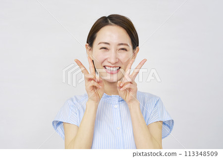 一個女人用雙手做和平標誌，白色背景 113348509