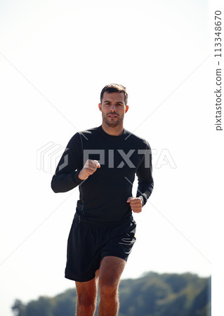 Running, athlete and man, outdoor and nature with energy for practice, exercise and health with sports. Workout, runner and training for marathon, forest and performance of speed of male person 113348670