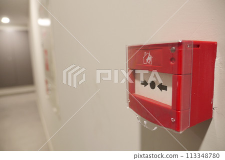 Red fire alarm button on wall , 113348780