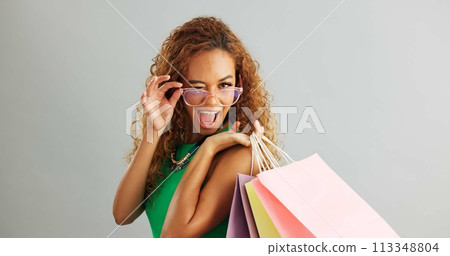 Woman, glasses and shopping bag in studio for fashion sale, discount and luxury with vision or eye care. Face of a young african person or happy model with cool and trendy style on a white background Woman, glasses and shopping bag in studio for fashion sale, discount and luxury with vision or eye care. Face of a young african person or happy model with cool and trendy style on a white background 113348804