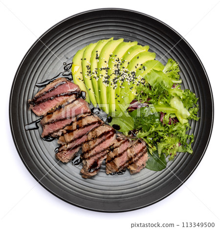 grilled cooked piece of tuna fillet with sliced avocado and salad on black ceramic plate grilled cooked piece of tuna fillet with sliced avocado and salad on black ceramic plate 113349500