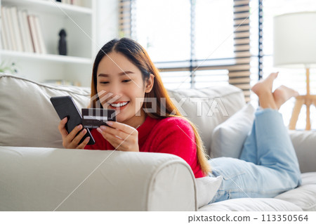 Young asian woman lying on sofa in living room 113350564