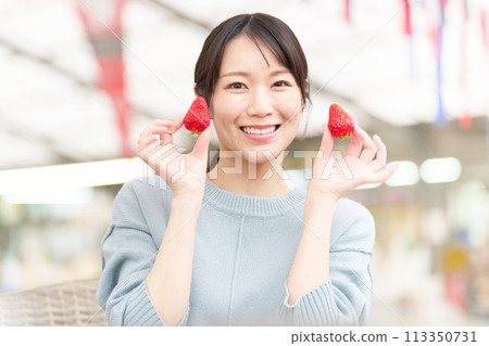 Smiling young woman holding strawberries in her hands Smiling young woman holding strawberries in her hands 113350731