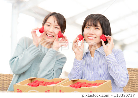 一個年輕女子手裡拿著草莓，微笑著 113350737