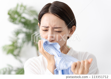 Woman holding laundry, damp 113351712