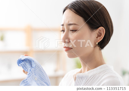 Woman holding laundry, damp 113351715