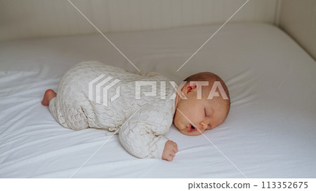 Portrait of cute little baby sleeping in bed, on belly, closed eyes. Portrait of cute little baby sleeping in bed, on belly, closed eyes. 113352675
