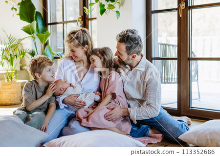 Portrait of nuclear family with newborn baby. Perfect moment. Strong family, bonding, parents' unconditional love for their children. Portrait of nuclear family with newborn baby. Perfect moment. Strong family, bonding, parents' unconditional love for their children. 113352686