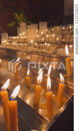 Candles are lit in the Catholic Church. 113353023