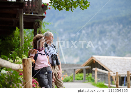 Active elderly couple on trip together, during spring day. Senior tourists visiting, exploring new places. Sightseeing, holding hands. Active elderly couple on trip together, during spring day. Senior tourists visiting, exploring new places. Sightseeing, holding hands. 113354565