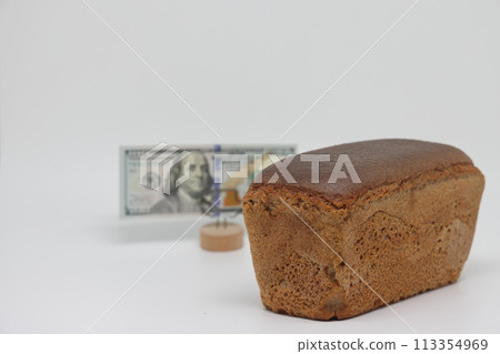 A loaf of black bread next to a banknote on the stand, the global food crisis, grain exports 113354969