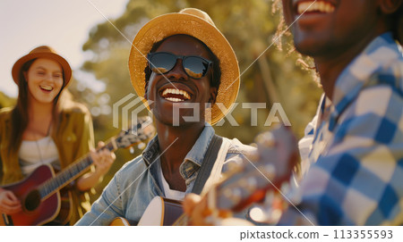 A group of interracial friends having fun with guitar and enjoying music at the park. Summer holidays, outdoor picnic A group of interracial friends having fun with guitar and enjoying music at the park. Summer holidays, outdoor picnic 113355593