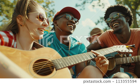 A group of interracial friends having fun with guitar and enjoying music at the park. Summer holidays, outdoor picnic A group of interracial friends having fun with guitar and enjoying music at the park. Summer holidays, outdoor picnic 113355594