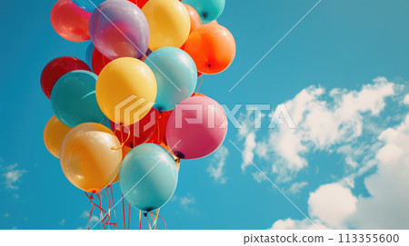 Colorful balloons with string tied together against a blue sky. Helium ballons floating in the air 113355600