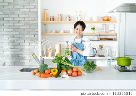 站立在廚房裡的一個微笑的少婦 113355813
