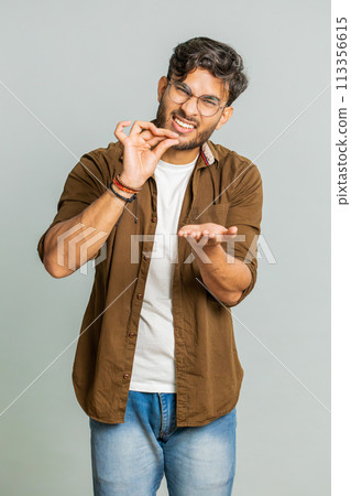 Man show a little bit gesture, begging help, need some more, please give me measuring small size 113356615