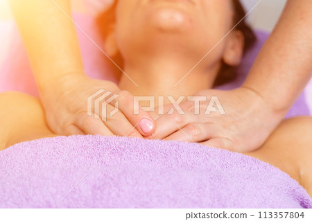Relaxing massage. European woman getting facial massage in spa salon, side view 113357804