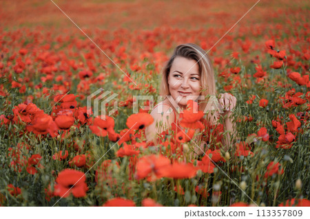 Happy woman in a red dress in a beautiful large poppy field. Blond sits in a red dress, posing on a large field of red poppies Happy woman in a red dress in a beautiful large poppy field. Blond sits in a red dress, posing on a large field of red poppies 113357809