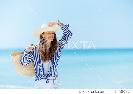 happy stylish woman on ocean coast happy stylish woman on ocean coast 113358032