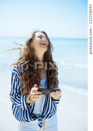 smiling stylish 40 years old woman on seacoast 113358043