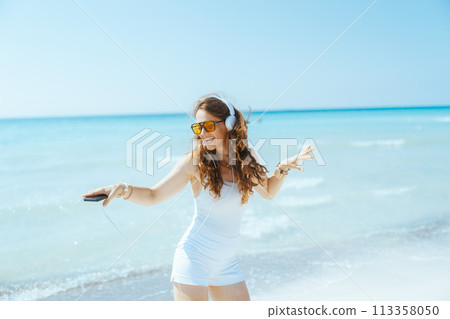 happy stylish 40 years old woman on seacoast dancing 113358050