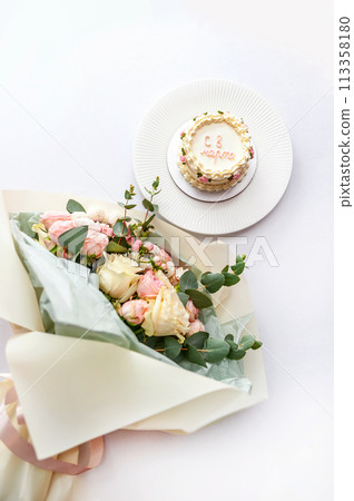 Festive bento cake and bouquet on a light background 113358180