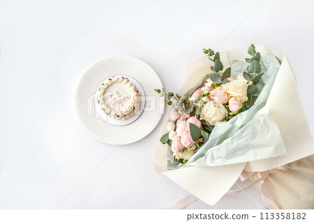 Festive bento cake and bouquet on a light background 113358182