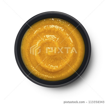 Pumpkin cream soup in black bowl isolated on white background, top view, package design element Pumpkin cream soup in black bowl isolated on white background, top view, package design element 113358343